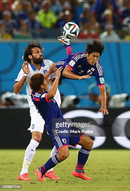 Atsuto Uchida of Japan competes for the ball with Giorgos Samaras of Greece during the 2014 FIFA World Cup Brazil Group C match between Japan and...
