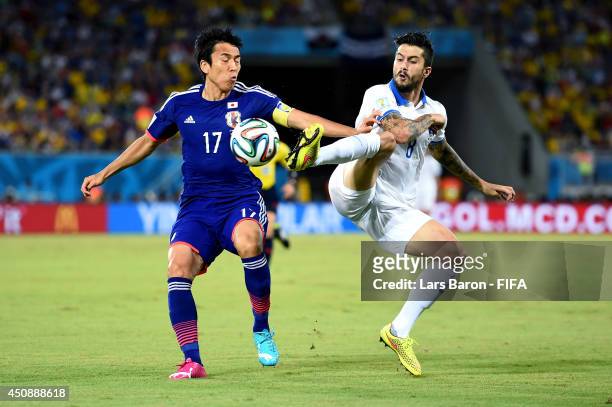 Panagiotis Kone of Greece and Makoto Hasebe of Japan compete for the ball during the 2014 FIFA World Cup Brazil Group C match between Japan and...