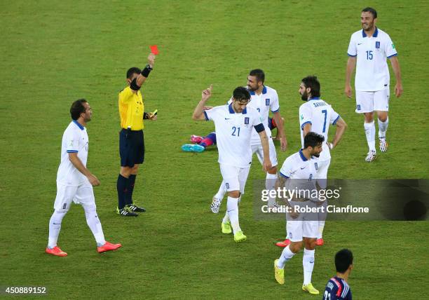 Konstantinos Katsouranis of Greece is shown a red card after receiving his second yellow by referee Joel Aguilar during the 2014 FIFA World Cup...