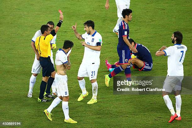 Konstantinos Katsouranis of Greece is shown a red card after receiving his second yellow by referee Joel Aguilar during the 2014 FIFA World Cup...