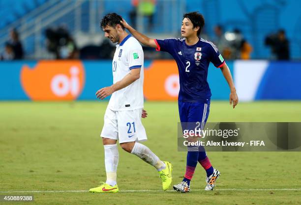 Konstantinos Katsouranis of Greece is consoled by Atsuto Uchida of Japan while walking off the pitch after receiving a red card during the 2014 FIFA...