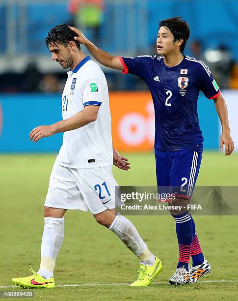 Konstantinos Katsouranis of Greece is consoled by Atsuto Uchida of Japan while walking off the pitch after receiving a red card during the 2014 FIFA...