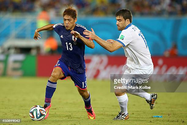 Yoshito Okubo of Japan controls the ball against Sokratis Papastathopoulos of Greece during the 2014 FIFA World Cup Brazil Group C match between...