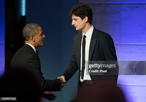 President Barack Obama shakes hands with Jack Schlossberg, the Grandson of President John F. Kennedy, after he introduced Obama, during a dinner in...