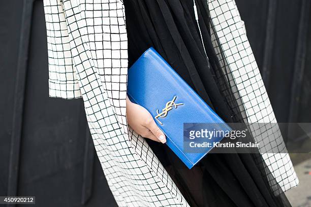 Fashion Student Fiona Dai wears a Topshop coat, KTZ dress and an Yves Saint Laurent clutch bag on day 2 of London Collections: Men on June 16, 2014...