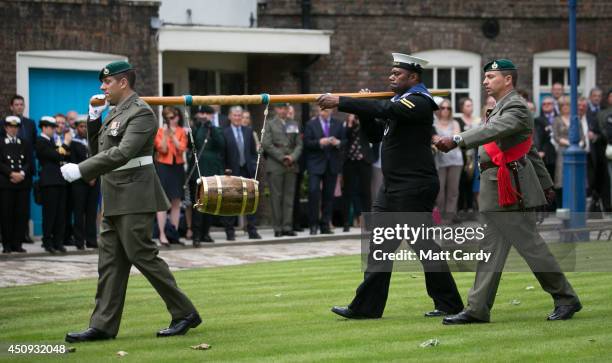 Royal Marines and Royal Naval personnel from 1 Assault Group Royal Marines deliver a barrel of rum as Royal Marines and Royal Naval personnel from 1...