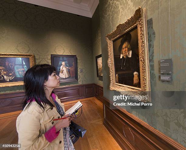 Journalist looks at 'Portrait of an Elderly Man' by Rembrandt van Rijn in the Late Rembrandt Room in the Mauritshuis Museum on June 20, 2014 in The...