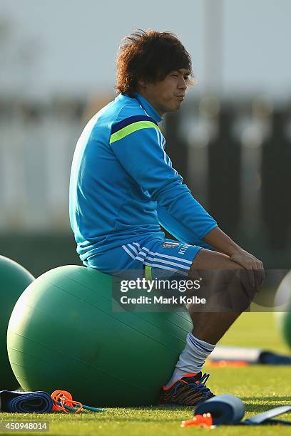 Yasuhito Endo sits on a ball as he waits for the start of the session during a Japan training session at the Japan national team base camp at the Spa...