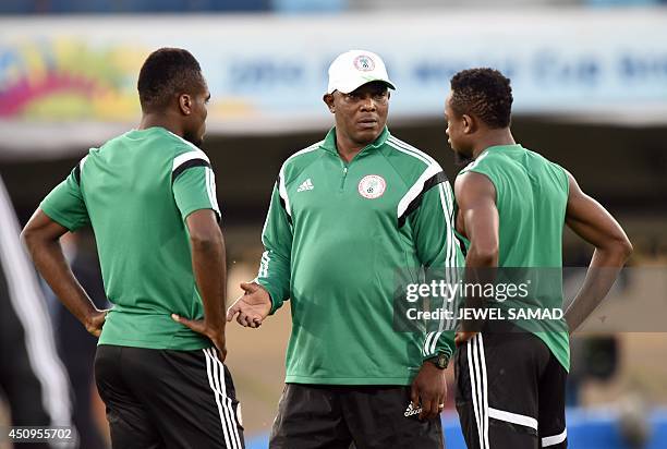 Nigeria's coach Stephen Keshi speaks with forward Emmanuel Emenike and midfielder Ogenyi Onazi during a training session at The Pantanal Arena in...