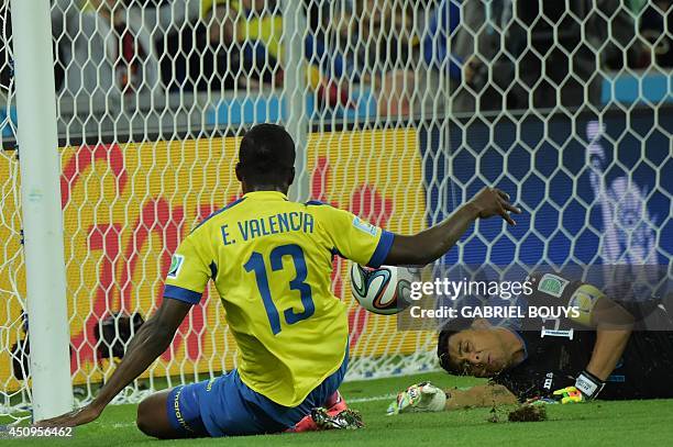 Ecuador's forward Enner Valencia scores past Honduras' goalkeeper and captain Noel Valladares during a Group E football match between Honduras and...