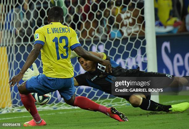 Ecuador's forward Enner Valencia scores past Honduras' goalkeeper and captain Noel Valladares during a Group E football match between Honduras and...