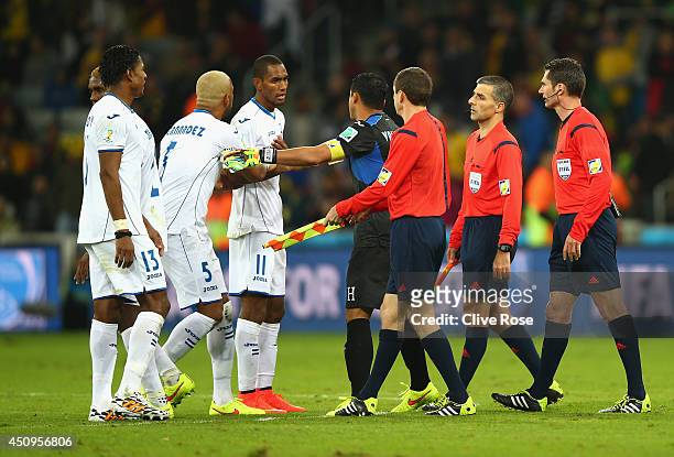 Jerry Bengtson of Honduras is held back by teammates as referee Benjamin Williams and assistant referees walk off the field at the half during the...