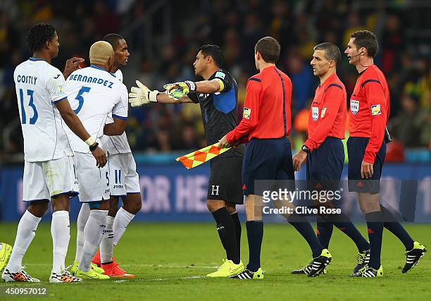 Jerry Bengtson of Honduras is held back by teammates as referee Benjamin Williams and assistant referees walk off the field at the half during the...