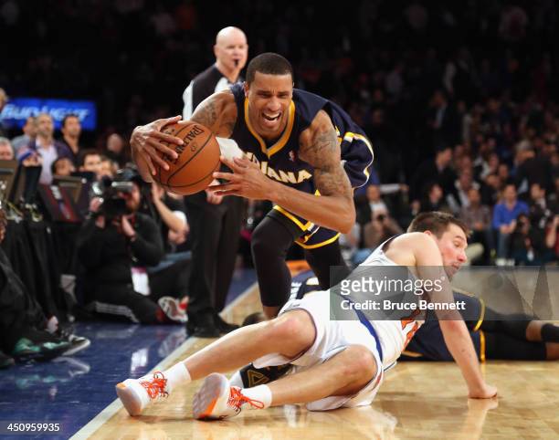 George Hill of the Indiana Pacers trips over Beno Udrih of the New York Knicks at Madison Square Garden on November 20, 2013 in New York City. NOTE...