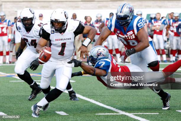 Henry Burris of the Ottawa Redblacks scrambles while being held by John Bowman of the Montreal Alouettes during the CFL game at Percival Molson...