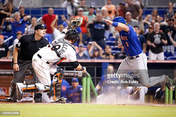 Jarrod Saltalamacchia of the Miami Marlins tags out Kirk Nieuwenhuis of the New York Mets at home plate to stop him from scoring the tying run and...