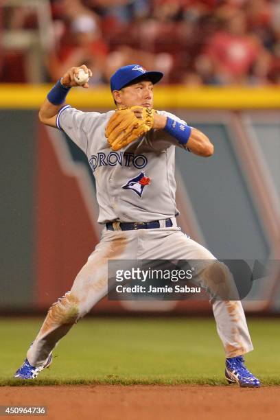 Munenori Kawasaki of the Toronto Blue Jays throws to first base to throw out a Cincinnati Reds batter after snagging a hard hit ball near second base...