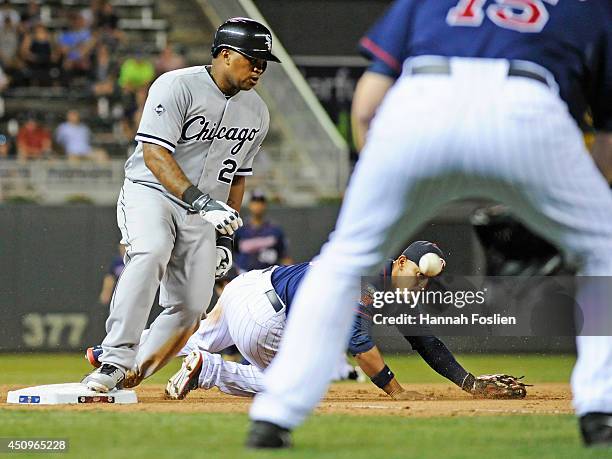 Dayan Viciedo of the Chicago White Sox slides into third base safely as Glen Perkins of the Minnesota Twins backs up teammate Eduardo Escobar as the...