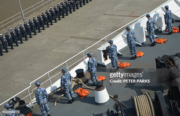 Sailors stand on the deck of the hospital ship Peace Ark bound for the typhoon-ravaged Philippines from a naval base in Zhoushan in China's eastern...