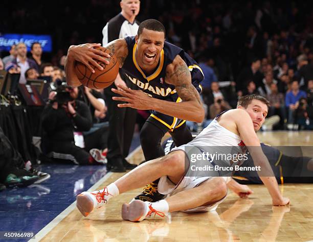 George Hill of the Indiana Pacers trips over Beno Udrih of the New York Knicks at Madison Square Garden on November 20, 2013 in New York City. NOTE...