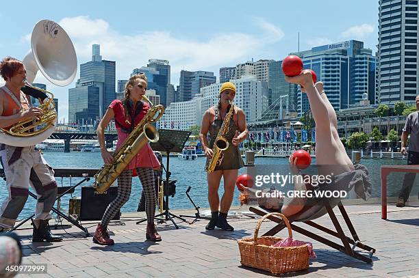 Circus Oz members Jez Davies, Ania Reynolds, Mason West and Hazel Bock perform at Sydney's Darling Harbour tourist precinct on November 21, 2013...