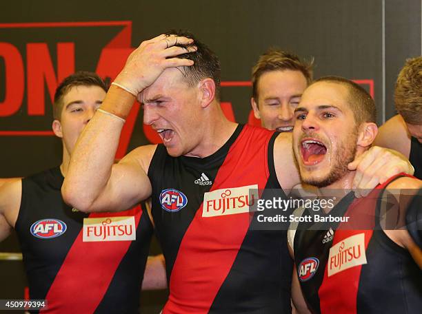 Brendon Goddard and David Zaharakis of the Bombers celebrate in the changing rooms as they sing the team song after winning during the round 14 AFL...