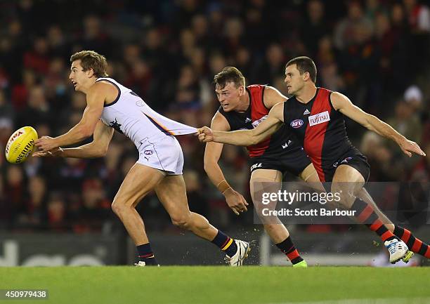 Jarryd Lyons of the Crows is tackled by Brendon Goddard of the Bombers during the round 14 AFL match between the Essendon Bombers and the Adelaide...