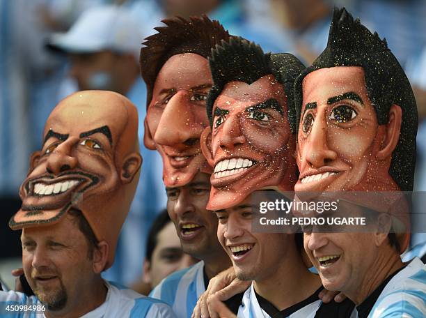 Argentina fans wearing masks bearing the faces of former Argentinian player Sebastian Veron, Argentina's forward and captain Lionel Messi,...