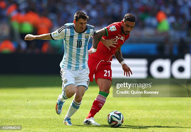 Lionel Messi of Argentina is challenged by Ashkan Dejagah of Iran during the 2014 FIFA World Cup Brazil Group F match between Argentina and Iran at...