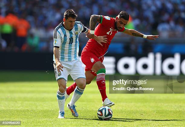 Lionel Messi of Argentina is challenged by Ashkan Dejagah of Iran during the 2014 FIFA World Cup Brazil Group F match between Argentina and Iran at...