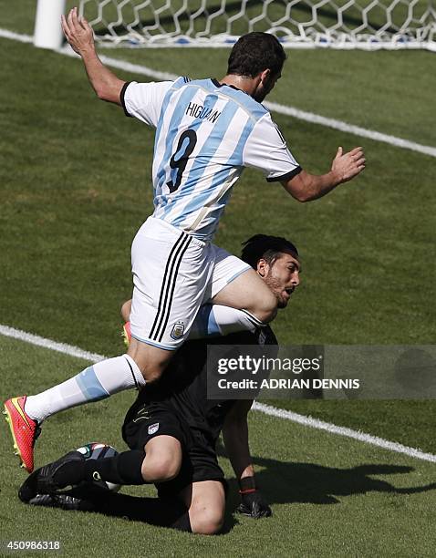 Argentina's forward Gonzalo Higuain and Iran's goalkeeper Alireza Haqiqi vie during the Group F football match between Argentina and Iran at the...
