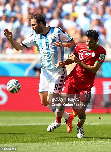 Gonzalo Higuain of Argentina and Pejman Montazeri of Iran clash during the 2014 FIFA World Cup Brazil Group F match between Argentina and Iran at...