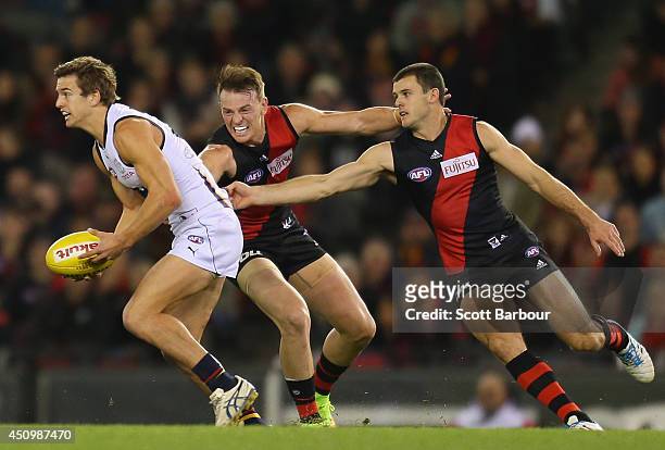 Jarryd Lyons of the Crows is tackled by Brendon Goddard of the Bombers during the round 14 AFL match between the Essendon Bombers and the Adelaide...