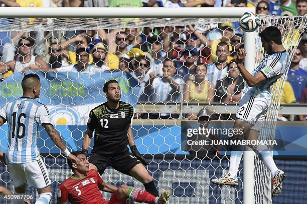 Iran's goalkeeper Alireza Haqiqi defends as Argentina's defender Ezequiel Garay makes an attempt on goal during the Group F football match between...