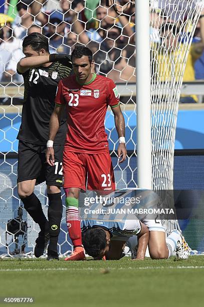 Argentina's defender Ezequiel Garay reacts after missing an attempt on goal as Iran's goalkeeper Alireza Haqiqi and Iran's defender Mehrdad Pooladi...