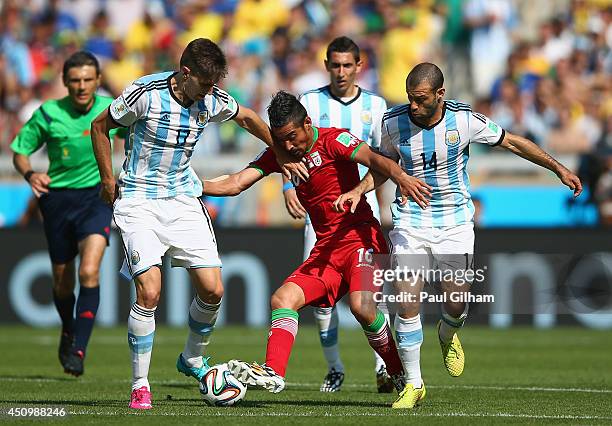 Reza Ghoochannejhad of Iran takes on Federico Fernandez and Javier Mascherano of Argentina during the 2014 FIFA World Cup Brazil Group F match...