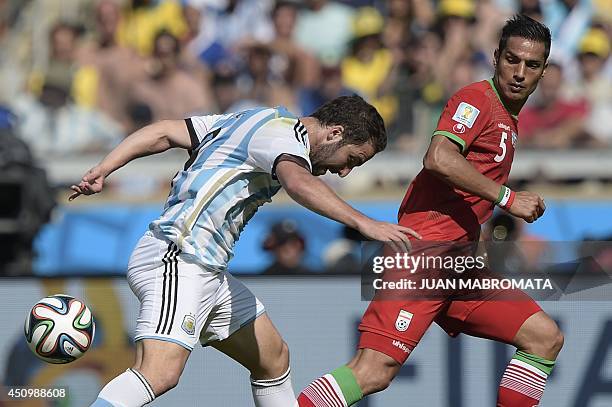 Argentina's forward Gonzalo Higuain and Iran's defender Amir Hossein Sadeqi vie for the ball during a Group F football match between Argentina and...