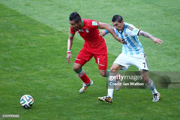 Reza Ghoochannejhad of Iran and Angel di Maria of Argentina compete for the ball during the 2014 FIFA World Cup Brazil Group F match between...