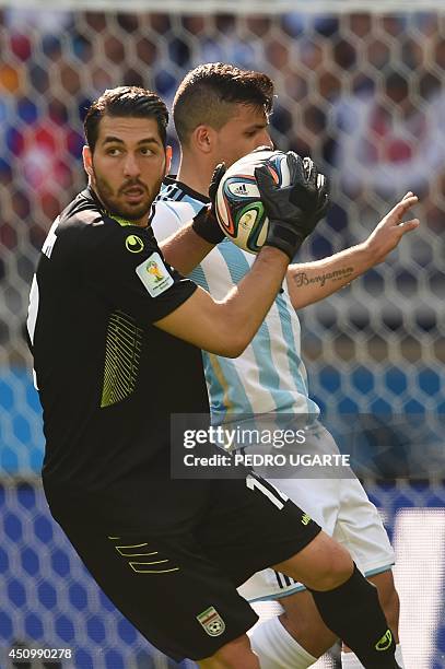 Iran's goalkeeper Alireza Haqiqi catches the ball after an attempt on goal during a Group F football match between Argentina and Iran at the Mineirao...