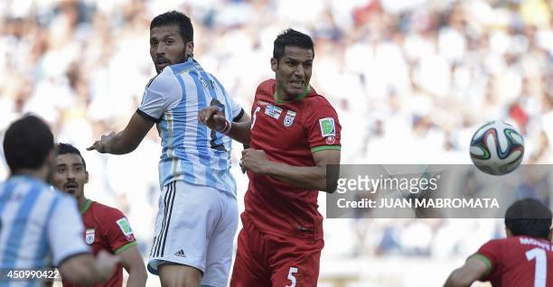 Argentina's defender Ezequiel Garay and Iran's defender Amir Hossein Sadeqi vie for the ball during a Group F football match between Argentina and...