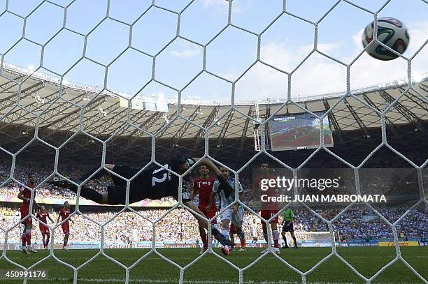 Iran's goalkeeper Alireza Haqiqi watches the ball go into the net as Argentina scores during a Group F football match between Argentina and Iran at...