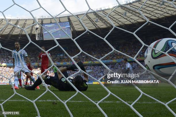 Iran's goalkeeper Alireza Haqiqi falls to the ground after failing to save the ball as Argentina scores during a Group F football match between...