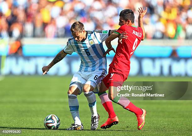 Lucas Biglia of Argentina fights off Alireza Jahan Bakhsh of Iran during the 2014 FIFA World Cup Brazil Group F match between Argentina and Iran at...