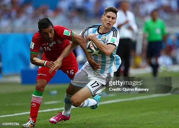 Federico Fernandez of Argentina competes for the ball with Reza Ghoochannejhad of Iran during the 2014 FIFA World Cup Brazil Group F match between...