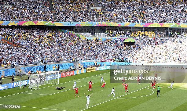 Iran's goalkeeper Alireza Haqiqi fails to save Messi's shot during the Group F football match between Argentina and Iran at the Mineirao Stadium in...