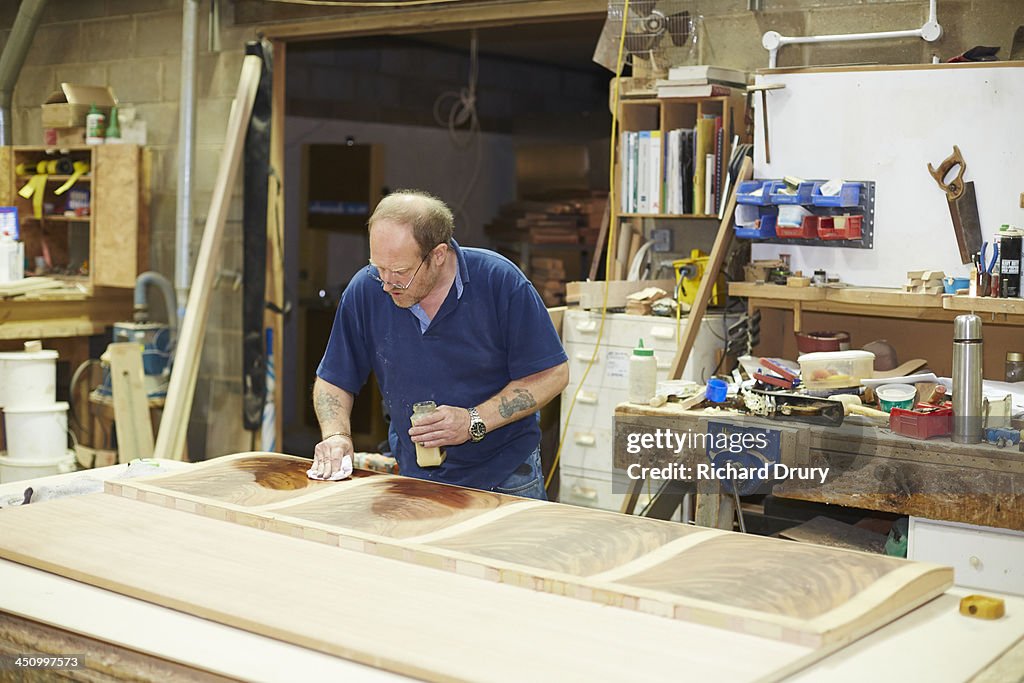 Craftsman sealing woodgrain before sanding