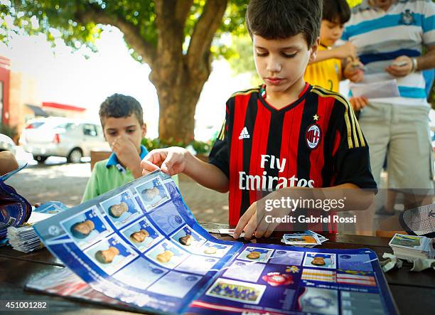 Kid checks his Panini 2014 FIFA World Cup Brazil sticker album at Praça Popular on June 21, 2014 in Cuiaba, Brazil.