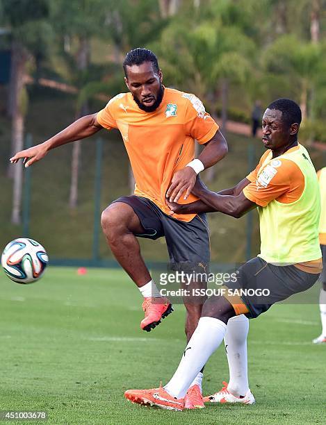 Ivory Coast's forward Didier Drogba and Ivory Coast's defender Ousmane Viera Diarrassouba take part in a training session in Aguas de Lindoia, on...