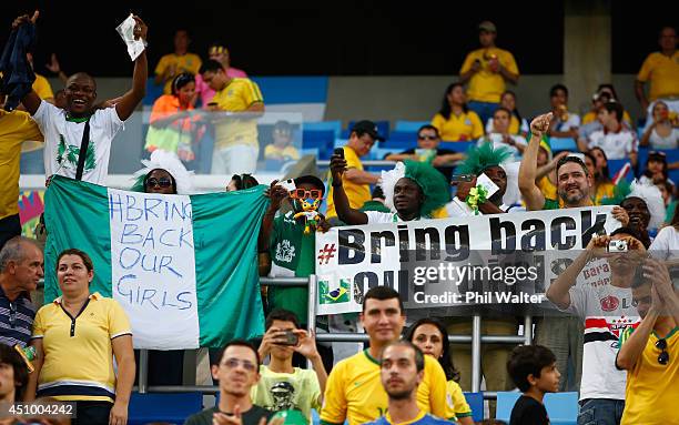 Fans show banners in support of the 'bring back our girls' campaign ahead of the 2014 FIFA World Cup Group F match between Nigeria and...