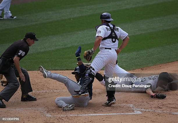 Jean Segura of the Milwaukee Brewers slides home to score as starting pitcher Christian Friedrich of the Colorado Rockies misses the tag and umpire...